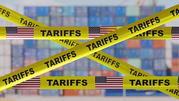 istock Tariffs text and US flag on yellow tape. Import tariff increase, Trade war concept 2209270359