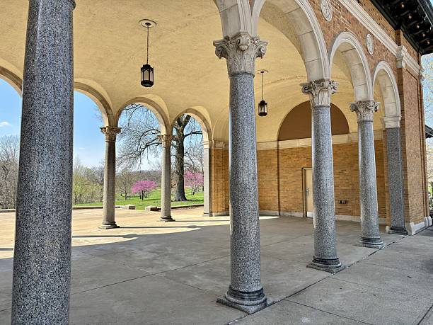 istock Granite columns and arched portico overlook blooming spring parkland 2209274953