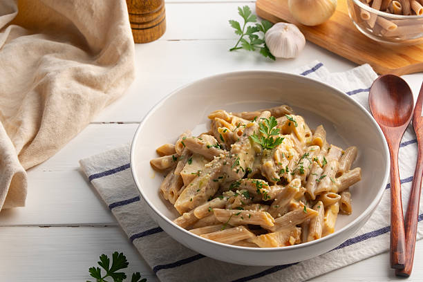 istock alfredo chicken pasta,Alfredo sauce with cooked penne rigate pasta 2209278754