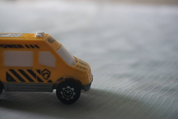 istock Yellow toy van on textured surface, blurred background, child's play 2209280605