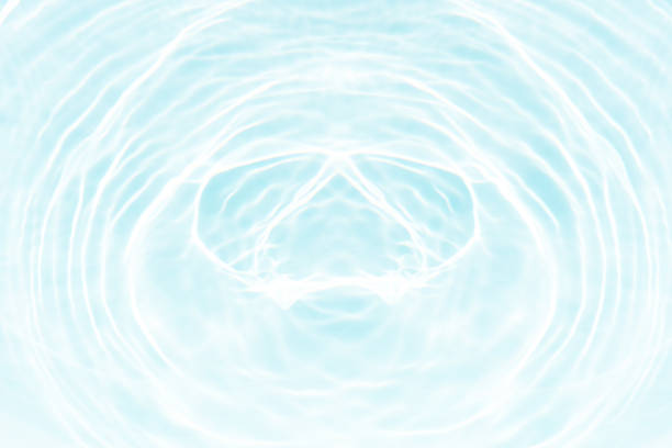 Golden ripples radiate through a fluid surface, showcasing an interplay of light and color. This image exudes warmth and serenity, evoking feelings of tranquility and the motion of liquid energy.