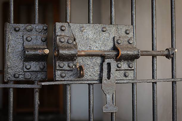 Close-up of a vintage iron jail cell lock with intricate details.