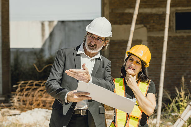 istock Senior Professional construction engineer guide suggest to women builder worker at construction site 2209295869