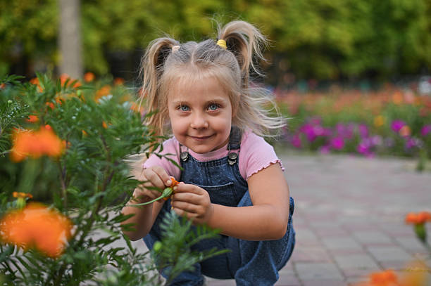 istock A little girl sniffs flowers on a walk 2209296598