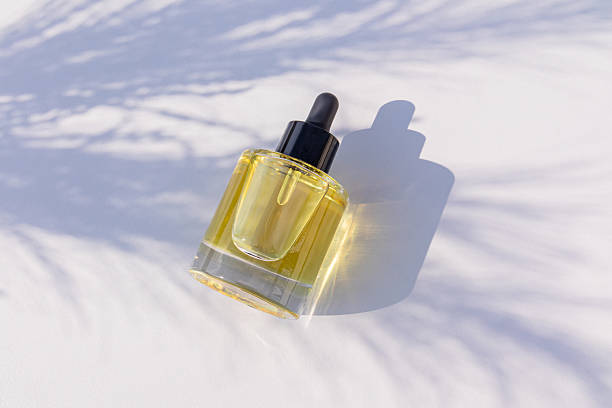 istock A chic bottle with a pipette with natural cosmetics on a light background with shadows from the branches. Top view. A copy space. blank bottle mockup. 2209296694
