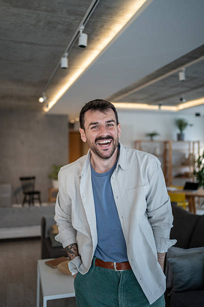 istock Young creative man smiling at camera in modern apartment 2209296956