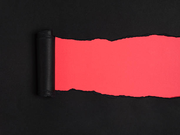 istock Ripped black rolled paper reveals a vibrant red underneath 2209299291