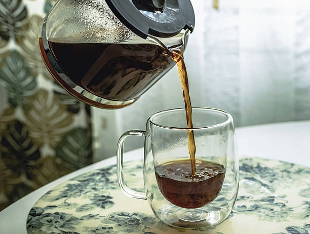 istock Hot coffee is poured into a glass mug. 2209300466