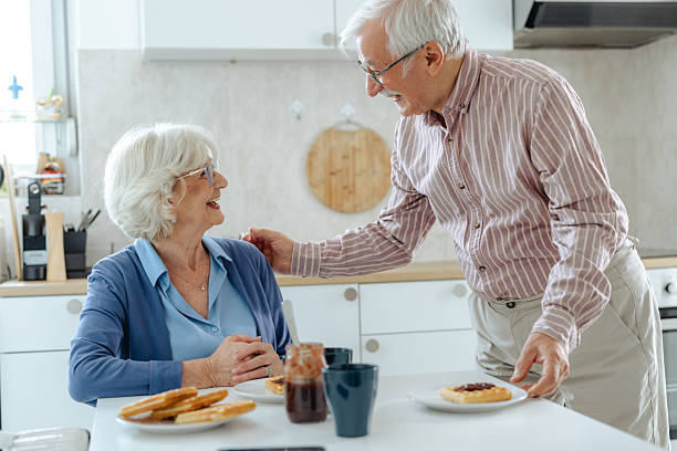 istock Elderly couple sharing a joyful moment together in a cozy kitchen setting 2209304179
