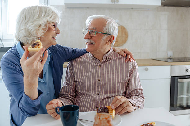 istock Senior couple enjoying quality time sharing a meal in a modern kitchen 2209304230