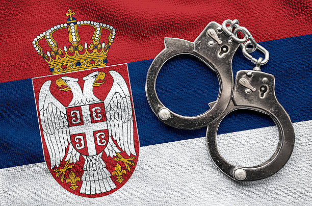Flag of Serbia and police handcuffs. stock photo