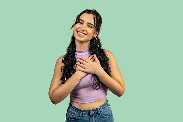 istock Young woman expressing gratitude and hope with hands on chest 2209306318