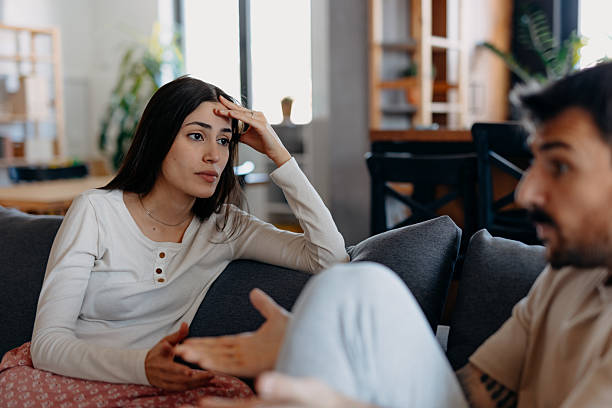 istock Young couple arguing while sitting on sofa at home 2209309296