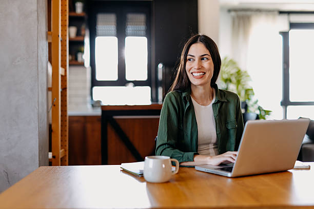 istock Young woman working from home, looking away and smiling 2209309833