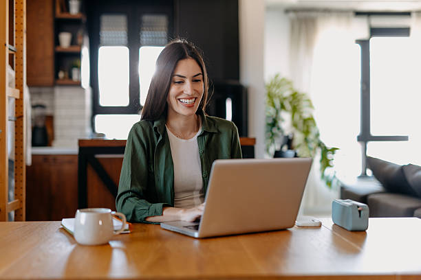 istock Young woman working from home smiling and using laptop 2209309834