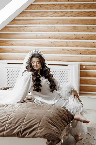 istock A woman is sitting on a bed with a feathery robe on 2209311802