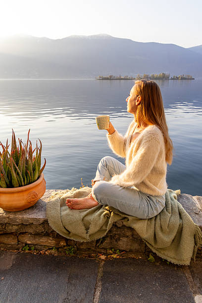 istock Woman Enjoying Morning Coffee by Lakeside 2209312903