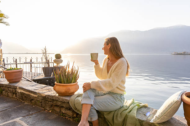 istock Woman Relaxing by Lakeside with Morning Sunlight 2209312906