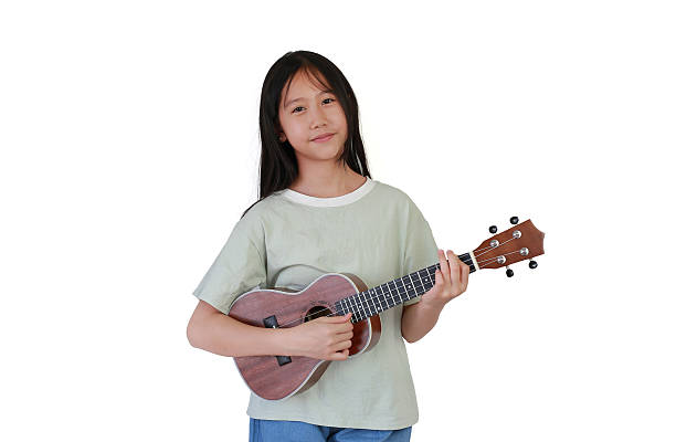 istock Portrait Asian young girl playing ukulele over white studio background. 2209315416