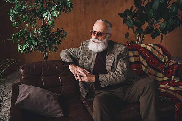 istock Stylish mature man with a white beard in a retro setting showcasing elegant and trendy fashion indoors in natural daylight 2209316004