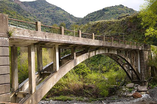 istock An ancient Italian stone arch bridge spanning a crystal clear mountain stream. 2209325352