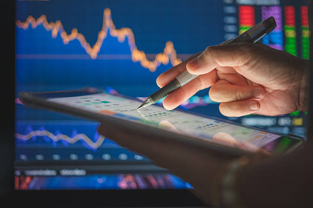 istock close-up of hand using tablet to plan investments analyzing market data with stylus on digital tablet in front of trading charts with Ai 2209325643