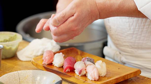 istock The hands of a chef preparing sushi 2209325792