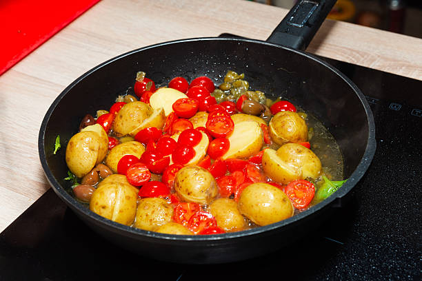 istock Sauteed baby potatoes and cherry tomatoes in pan. 2209326916