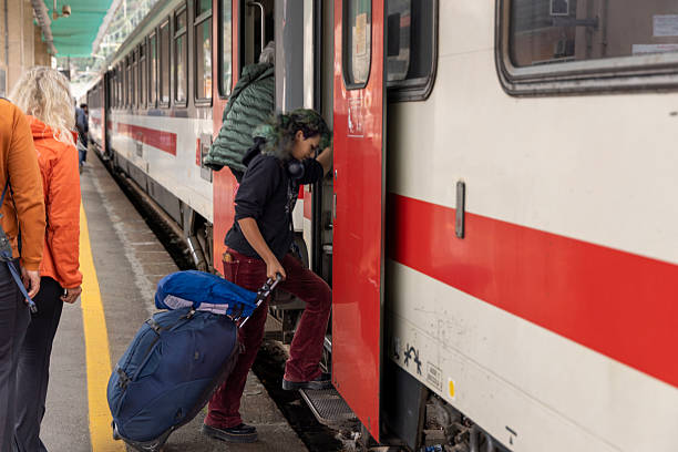 Generation Z woman climbs onboard train with luggage