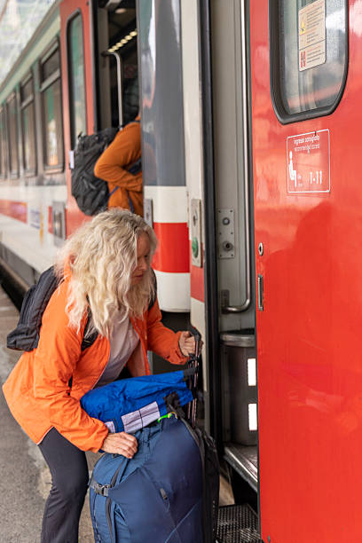 istock Mature woman loads luggage onto train 2209329298