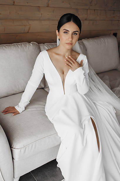 istock A woman in a white dress sits on a couch 2209330492