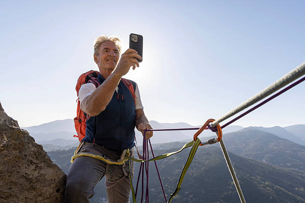 istock View down safety rope to climber taking photo on mountain top 2209331087