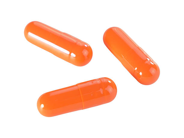 istock Bulk orange capsule pills isolated on white background. 2209332402