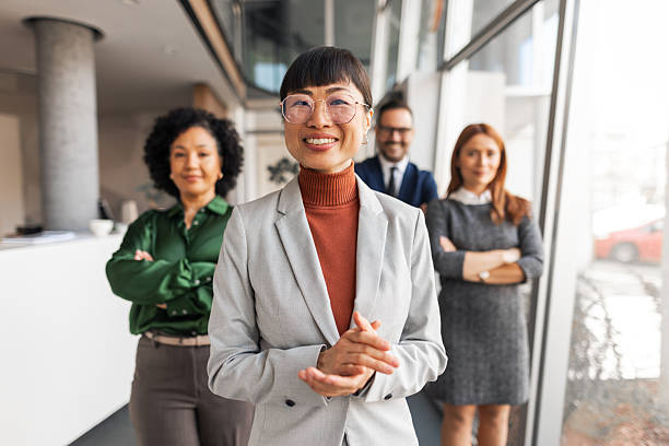 istock Confident Business Leader Smiling with Team in Modern Office Setting 2209334176