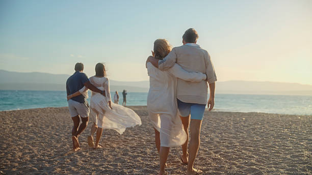 istock Joyful Mature Couples Strolling Along Zlatni Rat Beach at Sunset 2209335431
