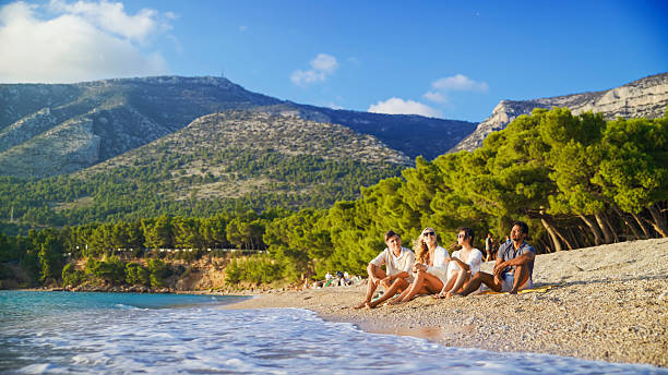 istock Diverse Couples Relaxing on Zlatni Rat Beach at Sunset with Scenic Mountain Backdrop 2209335478