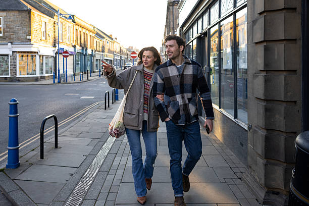 istock Young Couple Walking Arm-In-Arm Through Town 2209335901
