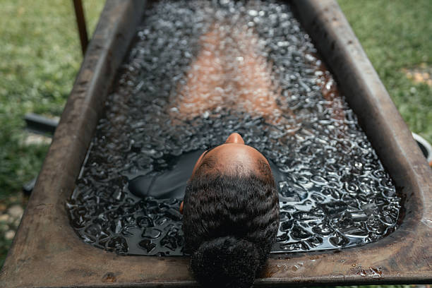 Women practicing necessary steps for ice bath therapy, pinching their noses with their fingers to hold their breath