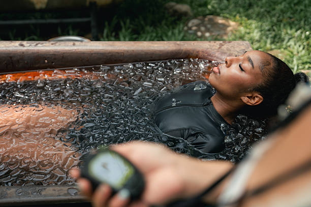 Women practicing necessary steps for ice bath therapy, pinching their noses with their fingers to hold their breath, listening carefully to the instructor, mentally preparing for a new and revitalizing healing experience