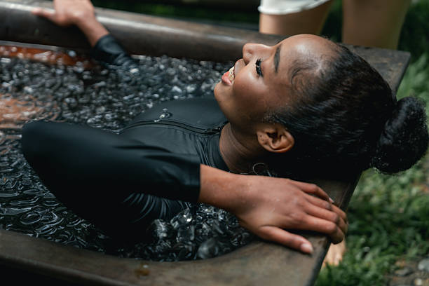 istock Women practicing necessary steps for ice bath therapy, pinching their noses with their fingers to hold their breath 2209336189