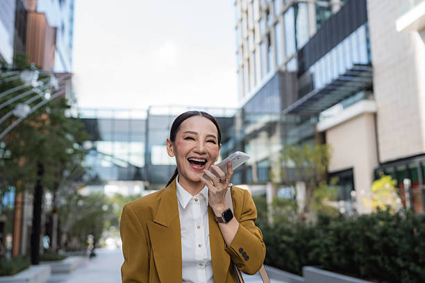 Confident senior business woman talking on a call cheerfully while walking in heels