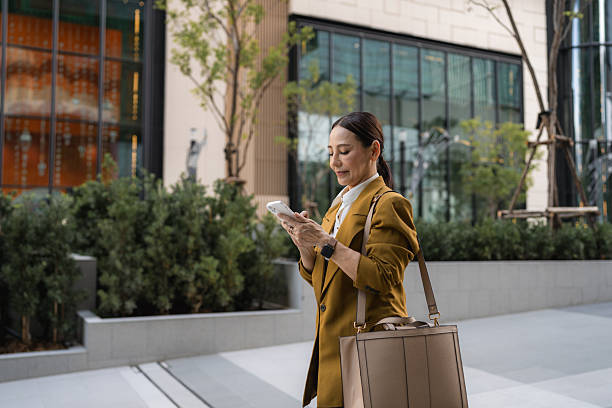 Confident Senior Businesswoman Cheerfully Texting While Walking in Heels