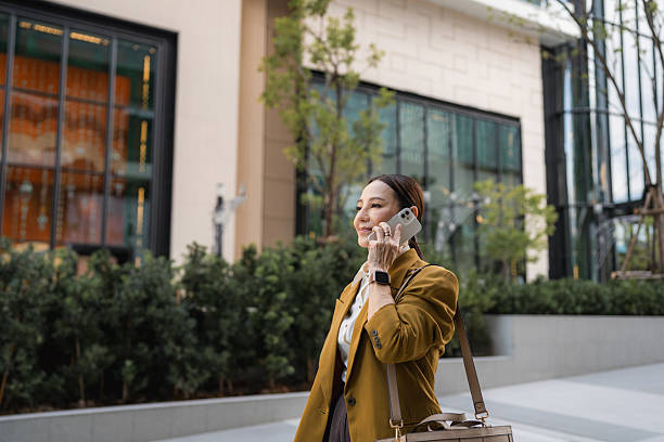 Confident senior business woman talking on a call cheerfully while walking in heels