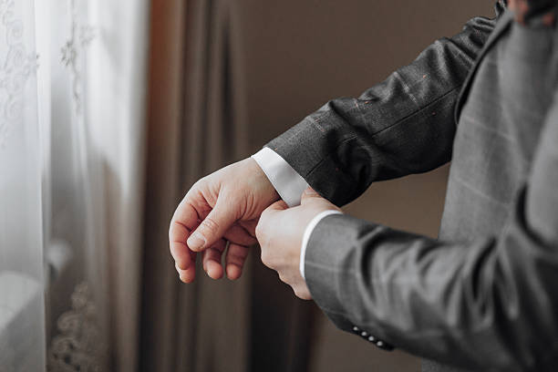 istock A man is getting dressed in a suit and tie 2209337198