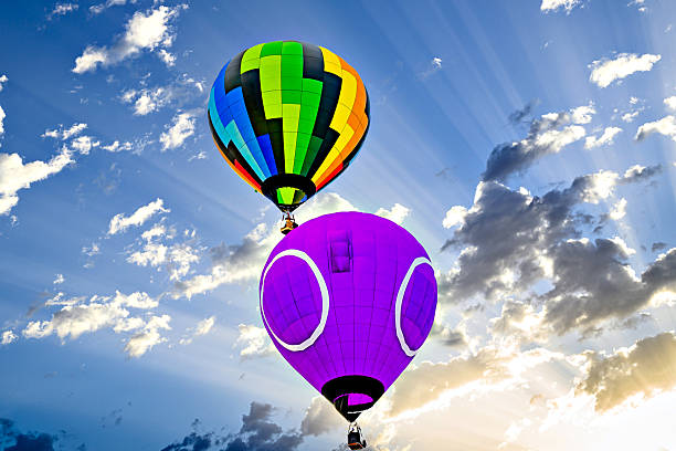 Colorful hot air balloon flying over blue sky with white clouds