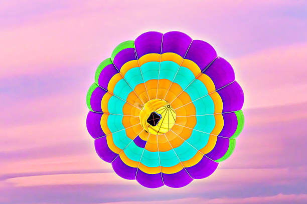 Colorful hot air balloon flying under orange sunset sky