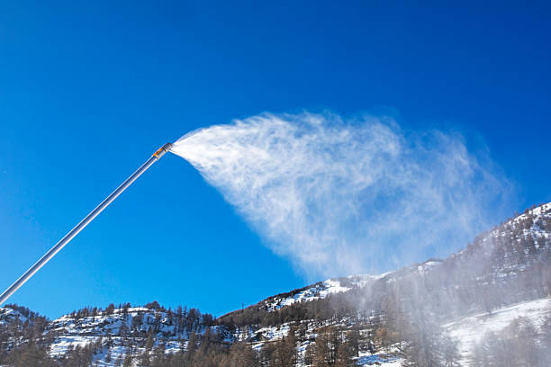 working snow generator against blue sky in the Alps.