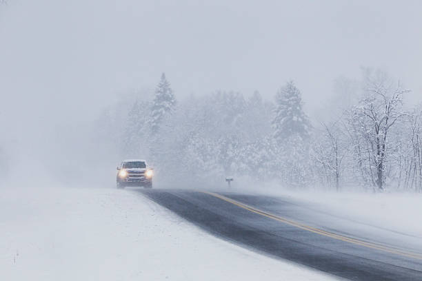 istock Car headlights on a snow covered road. 2209345561