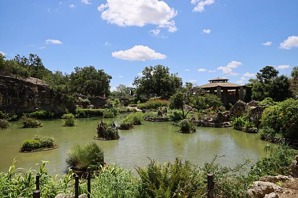 istock Scenic garden with pond and pavilion under blue sky. 2209345755