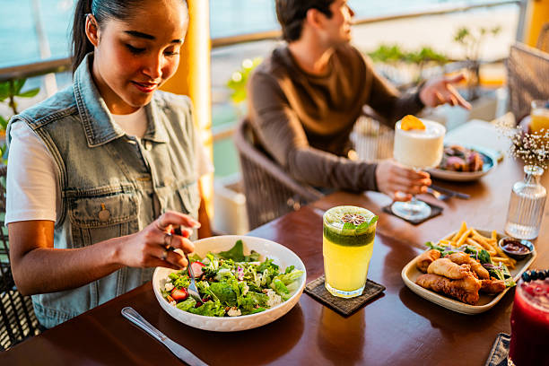 istock Young woman eating with friends on restaurant 2209346464